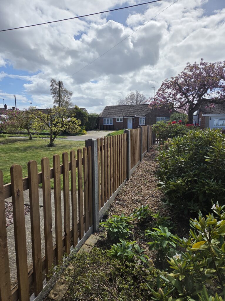 Timber picket fence running alongside garden boarder