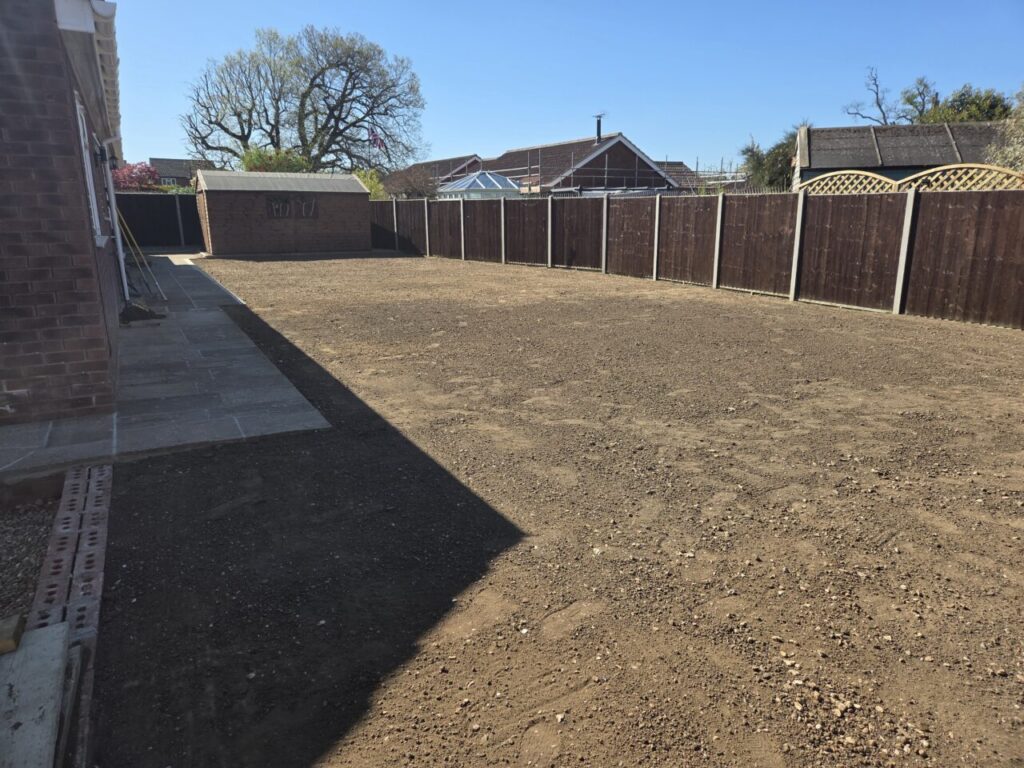 Newly levelled soil, surrounded by wooden fencing