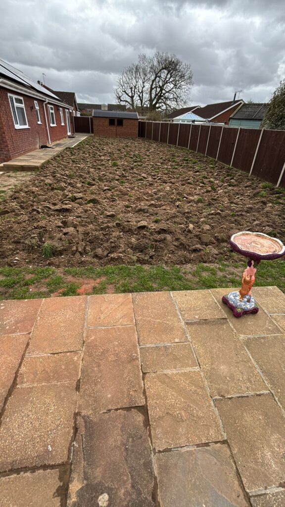 Dug up garden surrounded by patio tiles